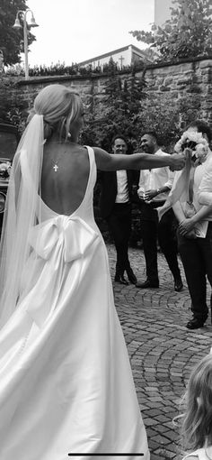 a woman in a wedding dress walking down the street