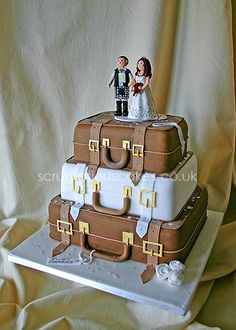 a wedding cake made to look like suitcases with a bride and groom on top