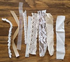 several different types of laces laid out on a wooden table with ribbons attached to them