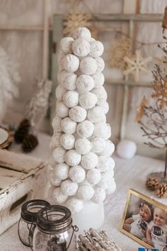 a christmas tree made out of snowballs on a table next to other holiday decorations