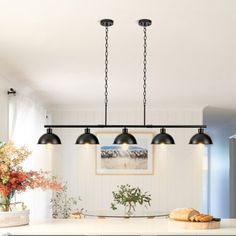 a kitchen island with three lights hanging over it