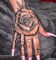 a woman's hand with tattoos on it and a rose tattooed on the palm