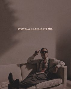 a man sitting on top of a couch in front of a wall with the words, every fall is a chance to rise