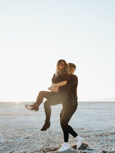 a man and woman are hugging on the beach