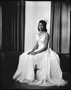 an old black and white photo of a woman in a dress