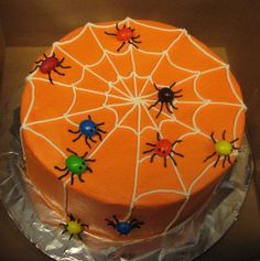 an orange cake with spider web decorations on it