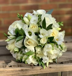 a bouquet of white flowers sitting on top of a wooden table