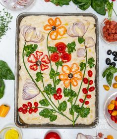 an assortment of vegetables laid out on top of a sheet of food that includes carrots, onions, tomatoes and other ingredients