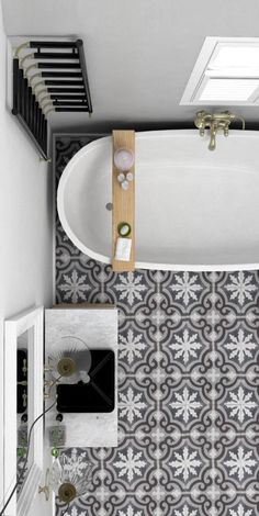 an overhead view of a bathtub and sink in a bathroom with black and white tile