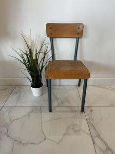 a wooden chair sitting next to a potted plant