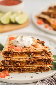 a stack of quesadillas with sour cream on top