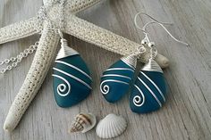 two blue and white seashells sitting on top of a table next to a starfish