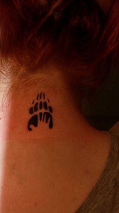 a woman with a tattoo on her neck has a bear paw in the shape of a heart