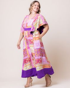 A bold print lends artisanal flair to the Mediterranean Breeze Boho Maxi Dress. This flattering plus size kaftan has a modest v-neck, empire waist and flowy short sleeves. Made from a lightweight rayon, this warm weather elegant gown is ideal for curvy guests of summer, beach, garden, tropical and destination weddings. This long dress can be styled for semi-formal events or pared down for the best dressy casual resort sundress or vacation and cruise outfit. Available in a unique pink and purple Summer Wedding Guest Dress, Plus Size Kaftan, Jumpsuit And Cardigan, Garden Tropical, Chic Cardigan, Beach Garden, Evening Gown Dresses, Maxi Dress Sale, Gowns Of Elegance