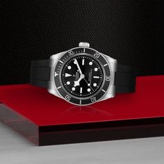 A Tudor "Black Bay" model wristwatch. The watch features a 41mm stainless steel case, a 60-minute unidirectional bezel in stainless steel with a red aluminum insert, a 70-hour power reserve, water proof to 200 meters, a black domed dial, a Manufacture Calibre MT5602-U self-winding mechanical movement with bidirectinoal rotor system, and a domed sapphire crystal. Five-year Guarantee: Five-year transferable guarantee with no registration or periodic maintenance checks required Case: 41mm stainless steel case with polished and satin finish Bezel: 60-minute unidirectional bezel in stainless steel with aluminum insert Movement: Manufacture Calibre MT5602-U. Self-winding mechanical movement with bidirectional rotor system. 70-hour power reserve Dial: black, domed Winding Crown: Stainless steel s Monochromatic Aesthetic, Rolex Tudor, Tudor Black Bay, Rubber Bracelets, The Tudor, Diamond Education, Custom Ring Designs, Fire Heart, Mechanical Movement