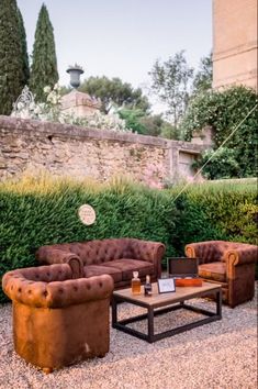 a living room filled with furniture next to a stone wall