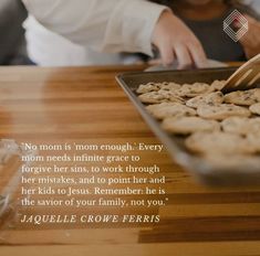 a woman scooping cookies into a pan on a wooden table with a quote about motherhood