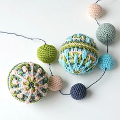 crocheted balls and string on white surface