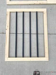 the frame is made out of wood and has four black rods sticking out of it