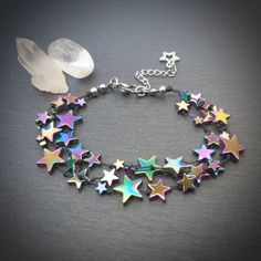 "This bracelet is made from rainbow coloured, star shaped hematite beads on waxed thread, with stainless steel findings and a tibetan silver charm  The bracelet comes in 2 sizes -  ⭐Small - Medium  Bracelet length 6.5 inches, plus 1.5 inch extender chain.  This will fit a wrist with a circumference of approximately 6 - 7 inches  ⭐Medium - Large Bracelet length 7.5 inches, plus 1.5 inch extender chain.  This will fit a wrist with a circumference of approximately  7 - 8 inches. As well as being a beautifully unique stone hematite is said to have a highly protective energy and is good for helping women who lack courage\". Disclaimer - we do not guarantee that this bracelet will make you brave 😉 Black hematite bracelet   https://www.etsy.com/uk/listing/800387014/star-shaped-hematite-bracelet- Rainbow Star-shaped Jewelry With Star Charm, Rainbow Star-shaped Bracelet For Gift, Multicolor Star Charm Bracelet, Handmade Rainbow Star Jewelry, Nerd Aesthetic, Rainbow Hematite, Boho Rock, Character Clothes, Protective Energy