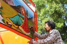 a man painting on the side of a truck