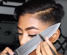 a woman holding a large knife over her face