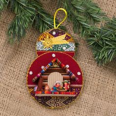 an ornament hanging from a christmas tree with ornaments on it's side