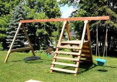 a wooden swing set in the grass