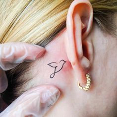 a close up of a person with a tattoo on their ear and behind the ear