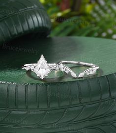 two wedding rings sitting on top of a green table