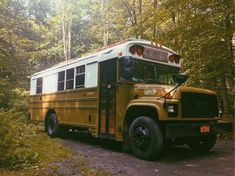 an old school bus parked in the woods