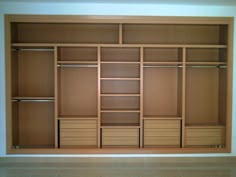 an empty closet with wooden shelves and drawers in it's center, next to a tiled floor