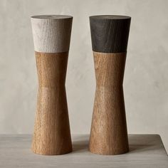 two wooden salt and pepper shakers sitting side by side