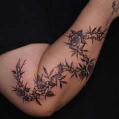 a woman's arm with tattoos on it and flowers in the middle of her arm