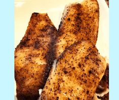 two pieces of chicken sitting on top of a white plate