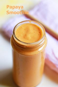 a glass jar filled with peanut butter sitting on top of a white tablecloth next to a pink napkin