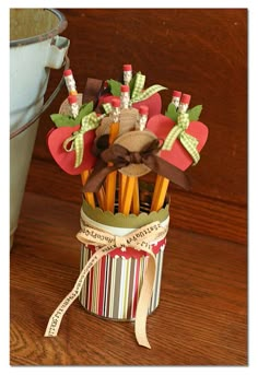 a cup full of pencils sitting on top of a wooden table