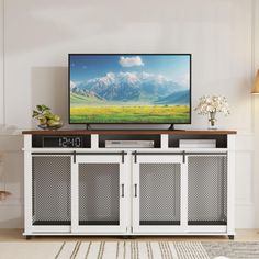 a flat screen tv sitting on top of a white cabinet