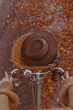 a person riding a bike with a brown hat on it's back wheel and two hands holding the handlebars