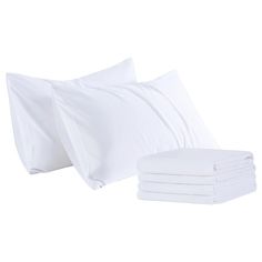 the white sheets and pillows are stacked on top of each other