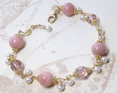 Beautiful Peruvian pink opals are accented with blush hued Swarovski crystals. Small white freshwater pearls dangle and make this bracelet unique and fun. A stunning gift for a woman born in October since the opal is her birthstone. A subtle natural pink gemstone jewelry, artisan and elegant, perfect for weddings and dressy occasions.Bracelet Details:- Pink opal gemstones are 9 mm. Pearls are 3 - 4 mm.- Bracelet length is 7.5 inches long (19.05 cm) plus a 1 inch extender- Handmade with 14k gold Pink And Pearl Bracelet, Opal Bracelet Gold, Pink Gemstone Bracelet, Pink Pearl Bracelet, Modern Wear, Birthday Stone, October Birthstone Jewelry, Stone Wedding, October Birthday