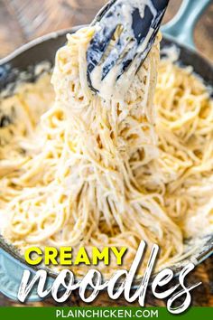 the noodles are being stirred with a ladle in a skillet on top of a wooden table