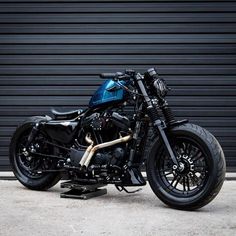 a black and blue motorcycle parked in front of a garage door