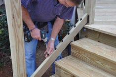 a man working on some wooden steps with a power drill and screwdriver in his hand