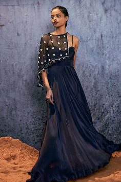 Midnight blue maxi dress with spaghetti straps in natural silk base. Paired with an asymmetric mirror embroidered cape with a tie-up. - Aza Fashions Festive Dress With Sheer Dupatta And Cape, Silk Sleeveless Dress With Sheer Dupatta, Sleeveless Silk Dress With Sheer Dupatta, Festive Dresses With Sheer Dupatta And Cape Sleeves, Festive Summer Dress With Cape Sleeves, Fitted Dresses With Sheer Dupatta And Cape Sleeves, Festive Maxi Dress With Draped Sleeves, Blue Maxi Dress With Cape Sleeves, Spring Festive Dress With Cape Sleeves