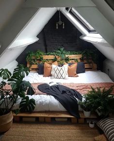 an attic bedroom with a bed and plants