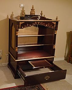 an old fashioned bookcase with drawers and other items on it in a living room