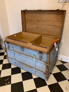 an old trunk sitting on top of a checkered floor