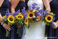 the bridesmaids are holding sunflowers and blue flowers