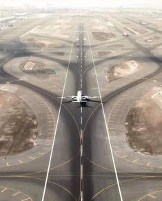 an airplane is flying in the air over some runways and roads that are lined with circles